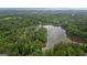 Aerial view of a serene lake surrounded by lush, green forest, highlighting the natural beauty of the landscape at 10 Wigwam Cir, Whitesburg, GA 30185