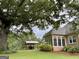 Expansive backyard featuring a covered patio, manicured lawn, and mature trees at 10 Wigwam Cir, Whitesburg, GA 30185