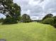 Vast lawn area with a view of the home and outbuildings, framed by mature trees at 10 Wigwam Cir, Whitesburg, GA 30185