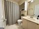 Bathroom featuring a vanity with a sink, a toilet with a cabinet above, and a shower with a striped curtain at 10 Wigwam Cir, Whitesburg, GA 30185