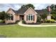 Charming brick home with manicured lawn, lush landscaping, and a welcoming entrance, offering timeless curb appeal at 10 Wigwam Cir, Whitesburg, GA 30185