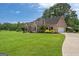 Expansive lawn leads to a brick home with attached garage and covered parking at 10 Wigwam Cir, Whitesburg, GA 30185
