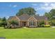 Charming brick home with manicured lawn, mature trees and an American flag, showcasing curb appeal at 10 Wigwam Cir, Whitesburg, GA 30185