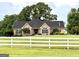 Charming brick home with a white picket fence and an American flag proudly displayed at 10 Wigwam Cir, Whitesburg, GA 30185