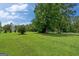 Expansive green lawn with mature trees, shrubs and white fencing offering a park-like setting at 10 Wigwam Cir, Whitesburg, GA 30185