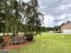 Inviting front yard features mature tree and bench overlooking lush lawn of brick home at 10 Wigwam Cir, Whitesburg, GA 30185