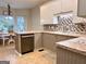 Modern kitchen featuring an island, stainless steel appliances, and a sleek tile backsplash at 10 Wigwam Cir, Whitesburg, GA 30185