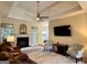 Spacious living room with fireplace, tray ceiling, and ample natural light from large windows at 10 Wigwam Cir, Whitesburg, GA 30185