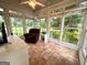 Sunroom features tile floors, a ceiling fan, and plenty of natural light from the surrounding windows at 10 Wigwam Cir, Whitesburg, GA 30185