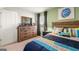 Inviting bedroom with colorful accents, a rustic wood dresser, and ample natural light at 351 Friendship Oak Way, Hampton, GA 30228