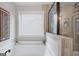 Bright bathroom featuring a tub and separate glass shower with tile surround at 372 Cobblestone Trl, Dallas, GA 30157