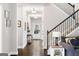Bright hallway with hardwood floors, staircase, and stylish lighting, seamlessly connecting different areas of the home at 372 Cobblestone Trl, Dallas, GA 30157