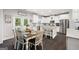 Bright kitchen and dining area with white cabinets, granite countertops, stainless steel appliances, and modern finishes at 372 Cobblestone Trl, Dallas, GA 30157