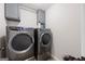 Laundry room showcasing new front load washer and dryer with upper cabinets at 372 Cobblestone Trl, Dallas, GA 30157
