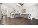 Open-concept living room featuring dark hardwood floors, a large sectional sofa, and stylish decor, ideal for gatherings at 372 Cobblestone Trl, Dallas, GA 30157