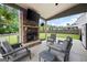 Inviting covered outdoor living space features a stone fireplace, TV and comfortable seating area at 372 Cobblestone Trl, Dallas, GA 30157