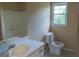 Simple bathroom with white sink, toilet, shower and a window providing natural light at 2763 Hunters Ct, Hampton, GA 30228