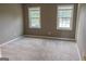 Bedroom with neutral walls, carpeted floors, and natural lighting from two windows at 2763 Hunters Ct, Hampton, GA 30228