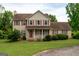 Traditional two-story home with red shutters, red front door, and well-maintained lawn at 2763 Hunters Ct, Hampton, GA 30228