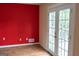 Living room showcasing red wall and bright french doors opening to outdoors at 2763 Hunters Ct, Hampton, GA 30228