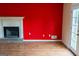 Bright living room with brick fireplace, red accent wall, and light wood floors at 2763 Hunters Ct, Hampton, GA 30228