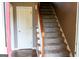 Carpeted staircase with wooden handrail near a white door at 2763 Hunters Ct, Hampton, GA 30228