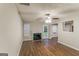 Spacious living room featuring a fireplace, ceiling fan, and wood-look flooring at 8330 N Sterling Lakes Dr, Covington, GA 30014