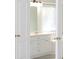 Elegant bathroom featuring white cabinets and a large mirror with a window in the background at 3700 Newhalem Sw St, Atlanta, GA 30331