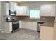 Modern kitchen featuring white cabinets, stainless steel appliances, and granite countertops at 3700 Newhalem Sw St, Atlanta, GA 30331