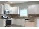 Modern kitchen featuring white cabinets, stainless steel appliances, and granite countertops at 3700 Newhalem Sw St, Atlanta, GA 30331
