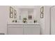 Bright bathroom featuring dual sinks, white cabinetry, and a large mirror at 139 Oakchase Park Ln, Hampton, GA 30228
