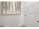 Neutral-toned laundry room with stylish art, white shelving, and tile flooring, blending form and function at 139 Oakchase Park Ln, Hampton, GA 30228