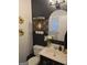Stylish powder room featuring black and white accents, decorative mirrors and a vanity sink at 10178 Top Tree Ct, Jonesboro, GA 30238