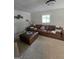 Spacious living room featuring neutral carpet, brown leather sofa and ottoman, and decorative wall art at 10178 Top Tree Ct, Jonesboro, GA 30238