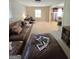 Living room with brown leather sectional sofa, large ottoman, and views into sitting room at 10178 Top Tree Ct, Jonesboro, GA 30238
