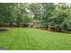 The exterior features a vast lawn, mature trees, covered deck, trampoline, and shed at 4080 Derby Dr, Cumming, GA 30040