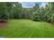 The property features a large, lush green backyard surrounded by mature trees at 4080 Derby Dr, Cumming, GA 30040
