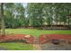Expansive backyard with lush green grass, mature trees, fire pit and lovely landscaping at 4080 Derby Dr, Cumming, GA 30040