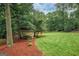 A charming shed with a lean-to roof sits on a well manicured lawn surrounded by trees at 4080 Derby Dr, Cumming, GA 30040