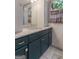 Bathroom vanity with blue cabinets, marble countertop, and a decorative mirror and lighting fixture at 4080 Derby Dr, Cumming, GA 30040