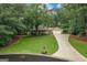 Aerial view of a landscaped two-story home with an extended driveway and a large front yard surrounded by mature trees at 4080 Derby Dr, Cumming, GA 30040