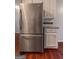 Modern kitchen with stainless steel refrigerator, white cabinets, granite countertops, and hardwood floors at 4080 Derby Dr, Cumming, GA 30040
