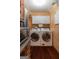Laundry room featuring appliances, upper shelving, and hardwood flooring at 4080 Derby Dr, Cumming, GA 30040