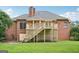 Brick home exterior showcasing a spacious backyard with a deck and ample greenery at 1214 Lambeth Se Way, Conyers, GA 30013