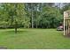 Spacious backyard features a lush lawn, mature trees, and direct access to the house via stairs at 1214 Lambeth Se Way, Conyers, GA 30013