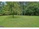 A huge backyard with lush green lawn and mature trees provides a serene and private outdoor space at 1214 Lambeth Se Way, Conyers, GA 30013