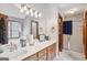 Bathroom featuring a double sink vanity, framed mirror, decorative wallpaper, and a glass enclosed shower at 1214 Lambeth Se Way, Conyers, GA 30013