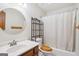 Bathroom featuring a white vanity, rounded mirror, and tub with shower curtain at 1214 Lambeth Se Way, Conyers, GA 30013
