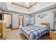 Bedroom featuring carpeted floors, double tray ceiling, and access to bathroom at 1214 Lambeth Se Way, Conyers, GA 30013