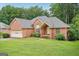 Beautiful red brick home with a well-maintained lawn and mature landscaping at 1214 Lambeth Se Way, Conyers, GA 30013